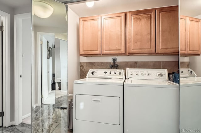 washroom with baseboards, marble finish floor, cabinet space, and washer and dryer