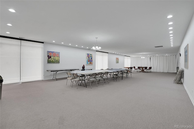 dining space with recessed lighting, light carpet, and a notable chandelier