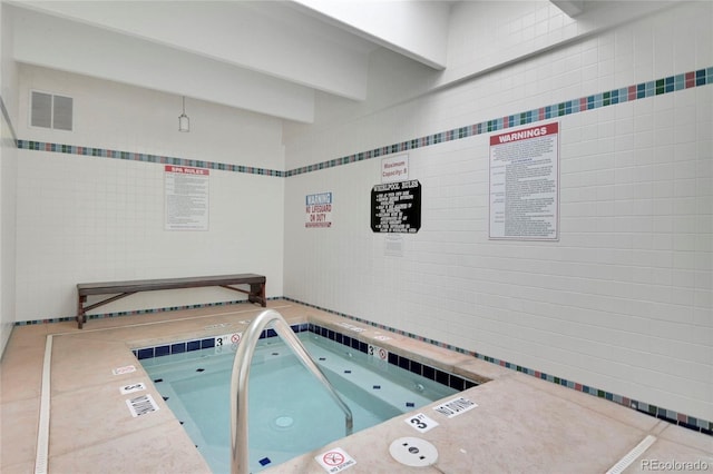 view of swimming pool featuring an indoor hot tub