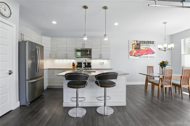 12497 W Virginia Ave, Lakewood, CO 80228 - kitchen featuring stainless steel appliances, modern cabinets, dark wood-type flooring, recessed lighting, and a kitchen breakfast bar
