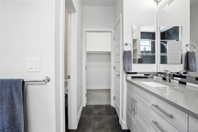 12497 W Virginia Ave, Lakewood, CO 80228 - bathroom with tile patterned floors, vanity, and a walk in closet