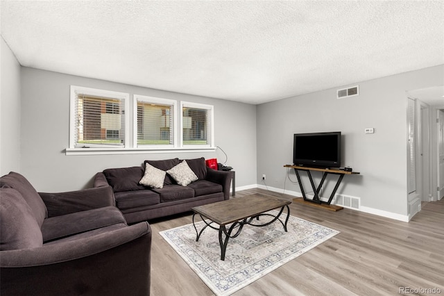 living room featuring a textured ceiling and light hardwood / wood-style flooring