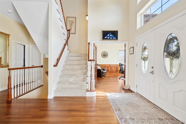 foyer entrance with light hardwood / wood-style floors and a high ceiling