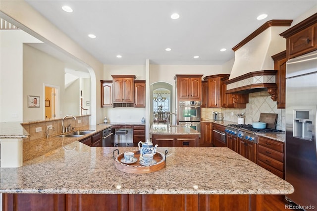 kitchen featuring sink, stainless steel appliances, kitchen peninsula, and premium range hood