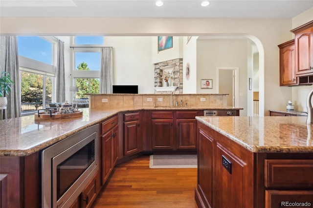 kitchen with a kitchen island, dark hardwood / wood-style floors, stainless steel microwave, and sink