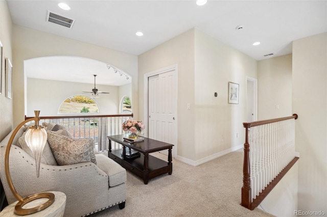 interior space with light carpet and ceiling fan