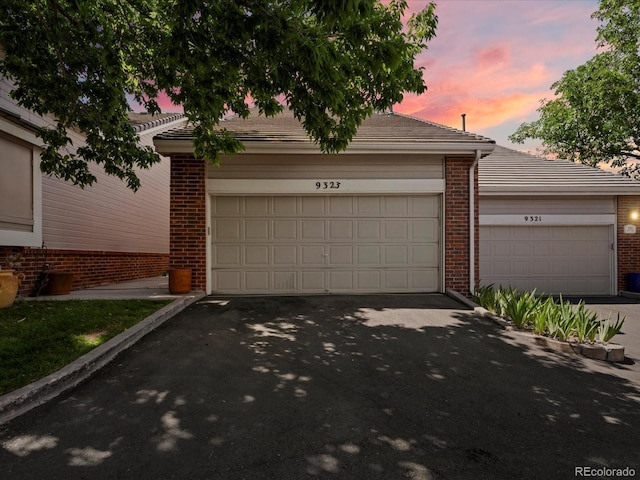 9323 Notts Ct, Lone Tree, CO 80124 - view of front of home with brick siding, a tiled roof, and a garage