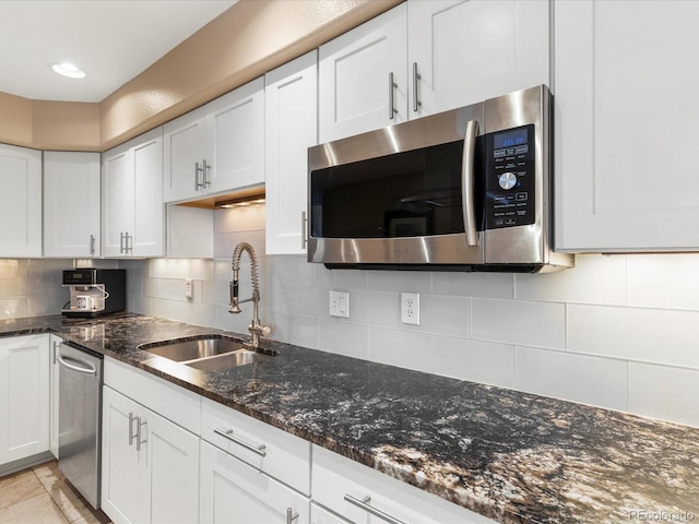 9323 Notts Ct, Lone Tree, CO 80124 - kitchen featuring stainless steel appliances, white cabinetry, tasteful backsplash, and dark stone countertops