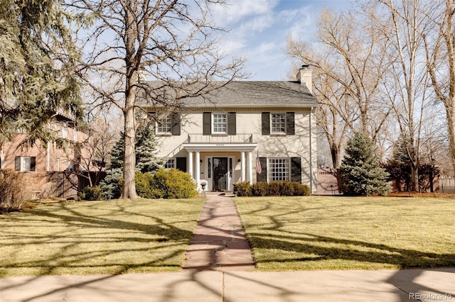 view of front of house with a chimney and a front lawn