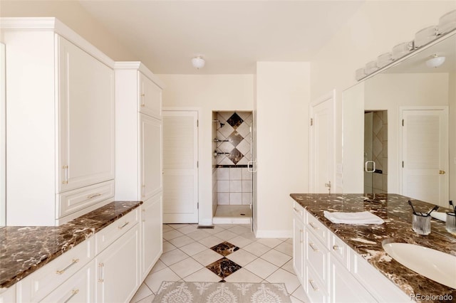 full bathroom featuring tile patterned floors, a stall shower, vanity, and baseboards