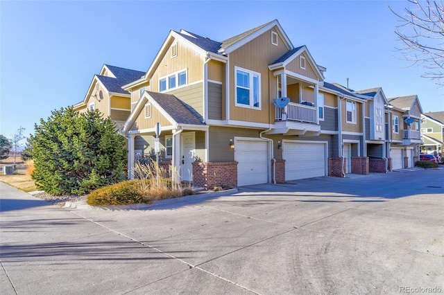 multi unit property with brick siding, board and batten siding, an attached garage, driveway, and a residential view
