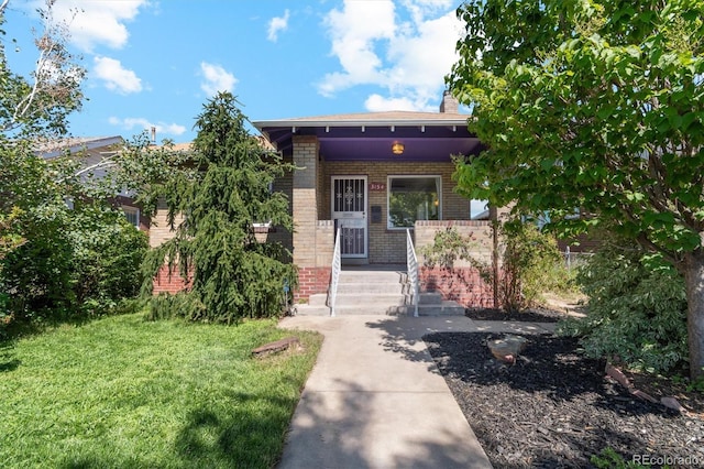 3154 N Columbine St, Denver, CO 80205 - view of front of home featuring brick siding, covered porch, a front yard, and a chimney