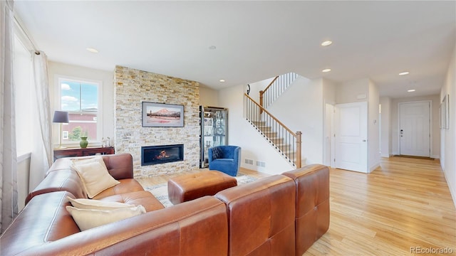 55 Morgan Cir, Erie, CO 80516 - living room with light wood finished floors, stairs, a fireplace, and recessed lighting