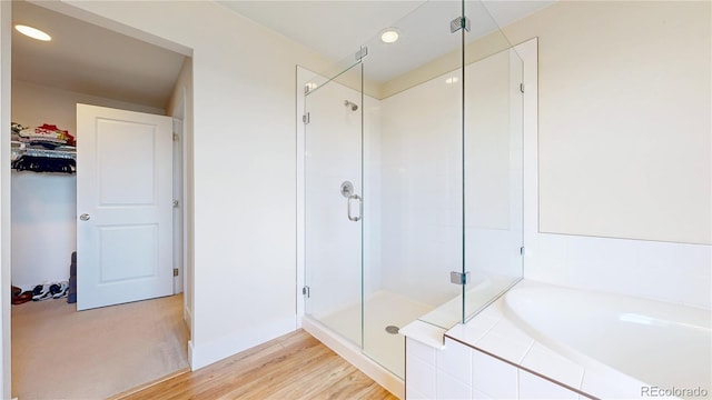 55 Morgan Cir, Erie, CO 80516 - full bath with a stall shower, a garden tub, recessed lighting, and wood finished floors