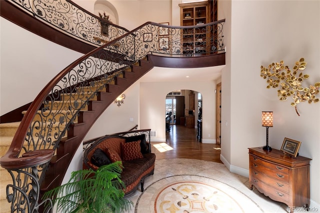 8002 Galileo Way, Littleton, CO 80125 - foyer featuring baseboards, a towering ceiling, arched walkways, and stairway