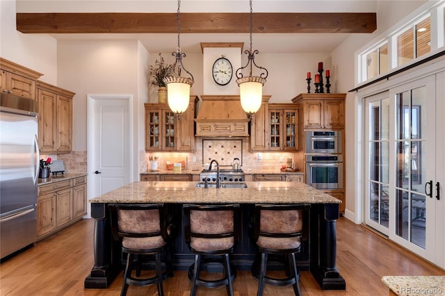8002 Galileo Way, Littleton, CO 80125 - kitchen featuring custom exhaust hood, a sink, stainless steel appliances, a center island with sink, and light wood finished floors