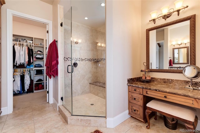 8002 Galileo Way, Littleton, CO 80125 - bathroom featuring a spacious closet, baseboards, vanity, and a stall shower