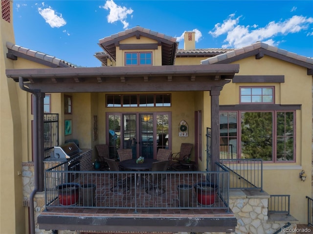 8002 Galileo Way, Littleton, CO 80125 - view of exterior entry with stucco siding, fence, and a tiled roof