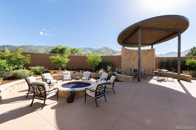 8002 Galileo Way, Littleton, CO 80125 - view of patio / terrace featuring fence, outdoor dining area, an outdoor fire pit, and a mountain view