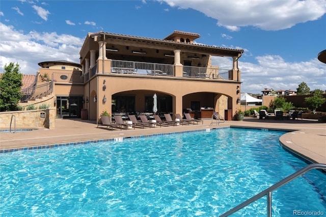 8002 Galileo Way, Littleton, CO 80125 - rear view of property with stucco siding, a community pool, a patio, and a balcony