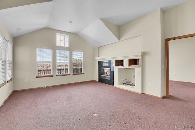 unfurnished living room with lofted ceiling, a tiled fireplace, and carpet flooring