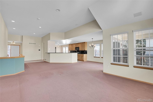 unfurnished living room with an inviting chandelier and carpet floors