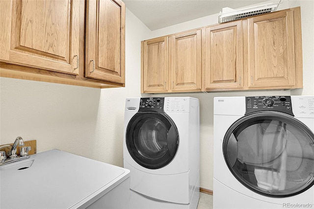 washroom featuring sink, cabinets, and washing machine and dryer