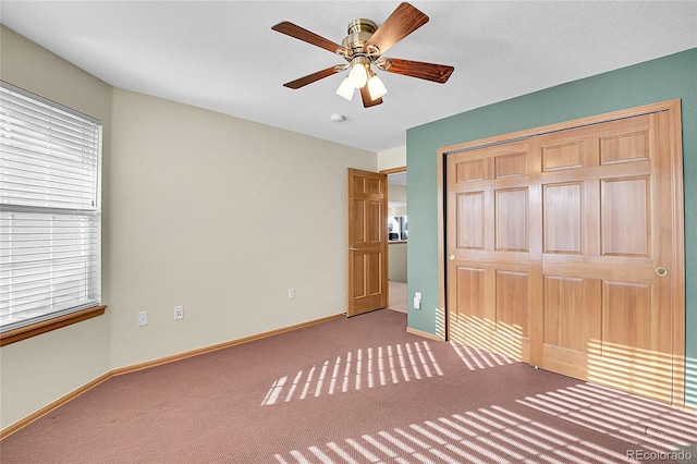 unfurnished bedroom with ceiling fan, a closet, and carpet floors