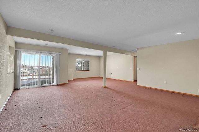 carpeted empty room with a textured ceiling