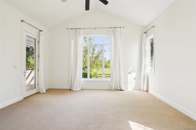 empty room featuring ceiling fan, vaulted ceiling, carpet floors, and baseboards