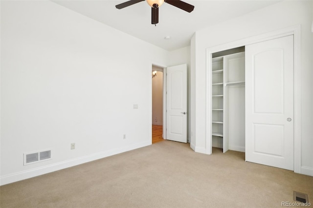 unfurnished bedroom with light colored carpet, baseboards, a ceiling fan, and a closet