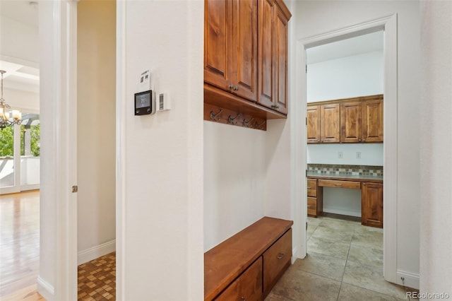 hall featuring a chandelier and baseboards