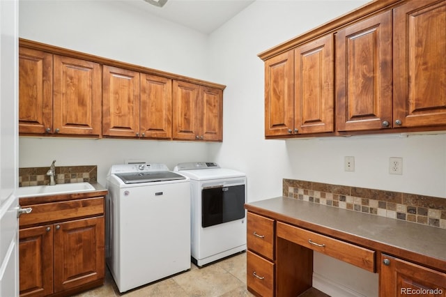 clothes washing area with cabinet space, washer and clothes dryer, and a desk