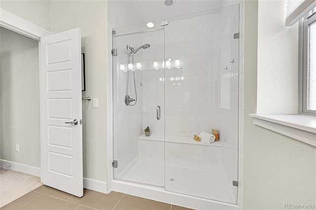 bathroom featuring baseboards, a shower stall, and tile patterned floors