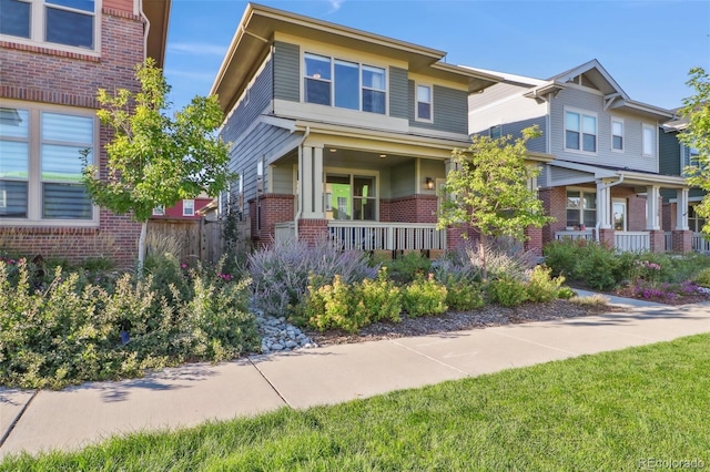 view of front of house featuring covered porch and brick siding