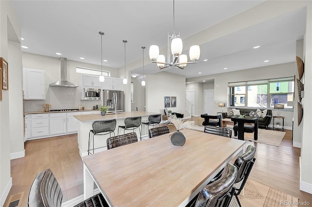 dining room with a chandelier, light wood-style flooring, and recessed lighting