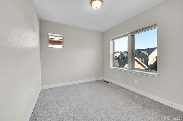 unfurnished room featuring carpet floors, a wealth of natural light, and baseboards