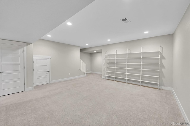 basement featuring carpet, visible vents, stairway, and recessed lighting