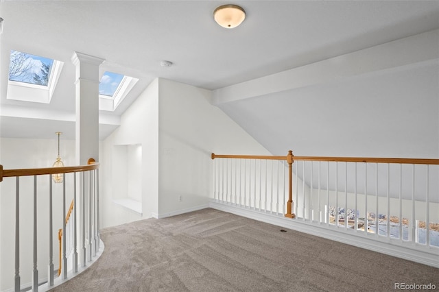 additional living space with vaulted ceiling with skylight and light colored carpet