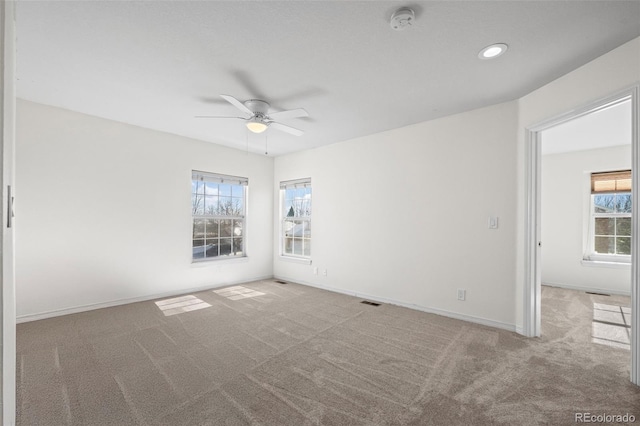 carpeted spare room featuring ceiling fan