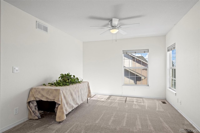 carpeted spare room featuring ceiling fan