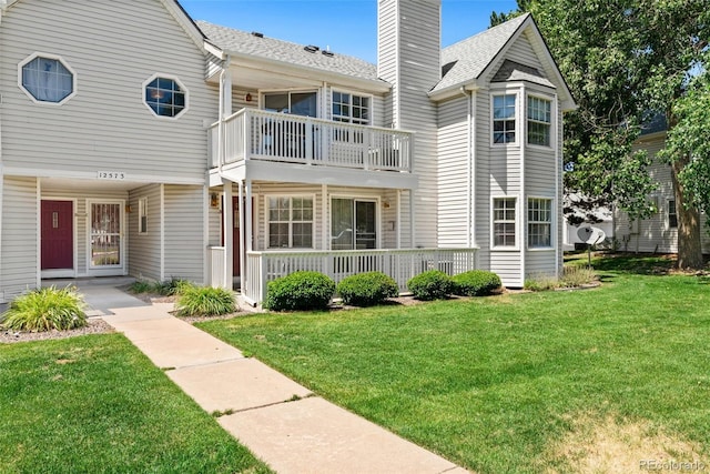 12573 E Pacific Cir Unit C, Aurora, CO 80014 - view of front facade with a balcony, a front lawn, a chimney, and roof with shingles