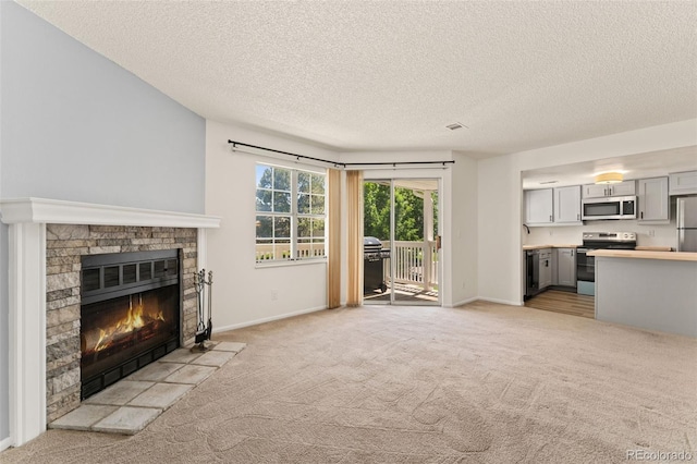 12573 E Pacific Cir Unit C, Aurora, CO 80014 - unfurnished living room with a fireplace, light colored carpet, and a textured ceiling