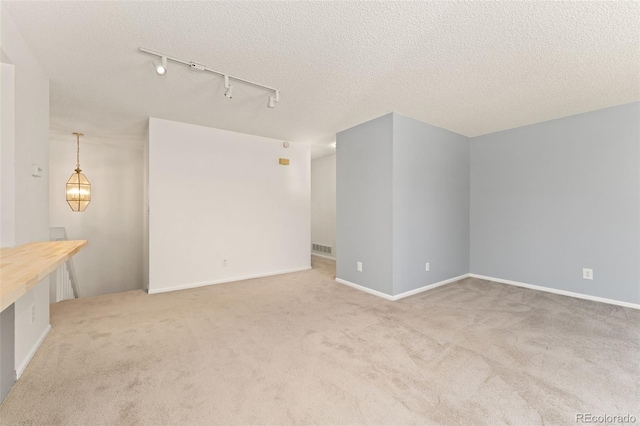 12573 E Pacific Cir Unit C, Aurora, CO 80014 - unfurnished living room featuring track lighting, carpet, and a textured ceiling