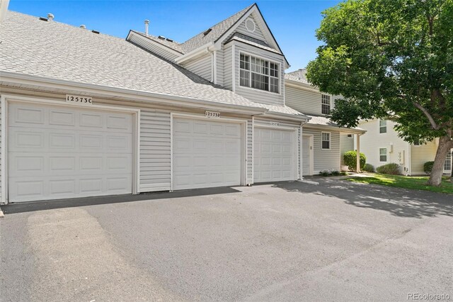 12573 E Pacific Cir Unit C, Aurora, CO 80014 - view of property featuring a shingled roof and community garages