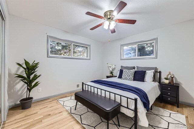 bedroom featuring light wood-style flooring, a ceiling fan, and baseboards