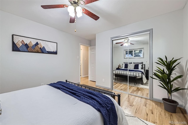 bedroom with baseboards, light wood-style flooring, and a ceiling fan