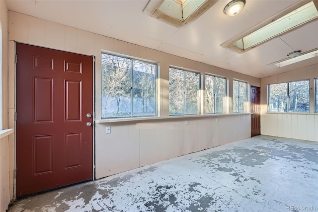 unfurnished sunroom featuring a skylight