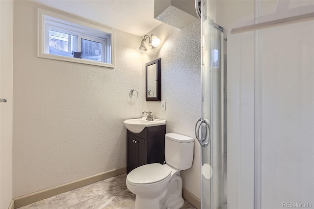 full bath featuring baseboards, toilet, a stall shower, a textured wall, and vanity