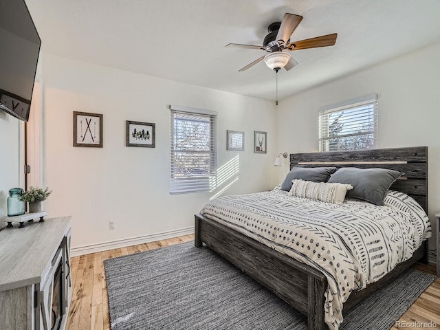 bedroom featuring multiple windows, ceiling fan, and light wood-type flooring